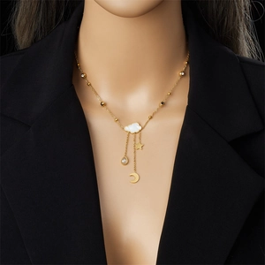 Golden necklace with white cloud pendant and celestial charms worn by a model