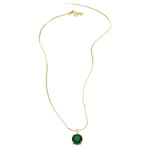 Detail of gold necklace with round green gemstone pendant and tiny zircon accents