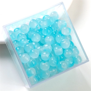 Macro view of blue translucent round glass jelly beads with cat eye effect in a box