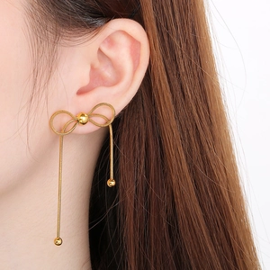 Détails des élégantes boucles d'oreilles papillon dorées avec de fines chaînes