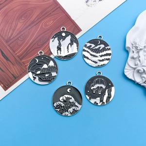 Set of five round black and white enamel pendants featuring nature landscapes and waves