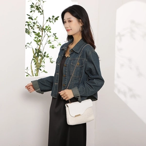 Elegant white woven straw handbag with gold chain strap shown in a professional studio setting