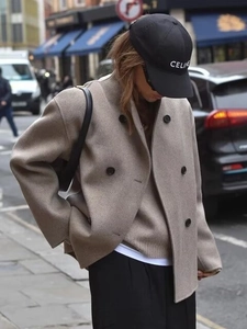 Street style view of double-breasted oatmeal wool blend coat with black buttons detail
