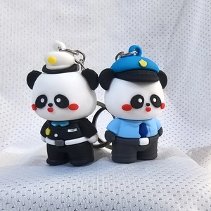 Close-up of cute silicone panda keychains in black and blue uniforms for bags