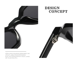 Detailed macro view of black polygonal sunglasses showing metal hinges and frame texture