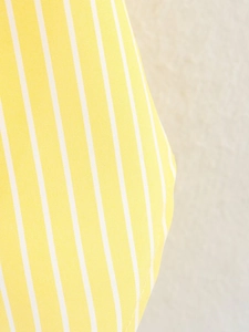 Macro shot of vertical yellow and white striped fabric with premium cotton weave texture