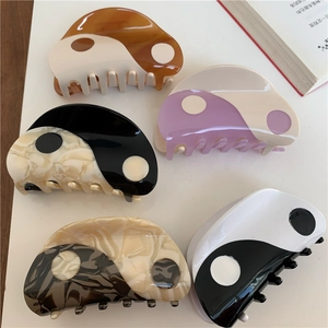 Detailed view of yin-yang hair claws in five colors on a clean white background