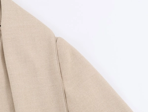 Close-up of fine stitching and woven texture on a beige casual blazer jacket
