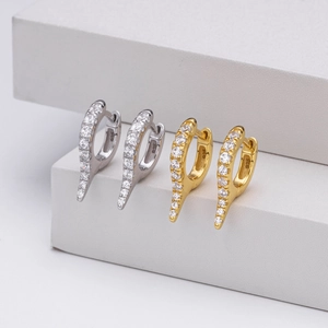 Macro detail of gold and silver S925 sterling silver hoop earrings with clear gemstones