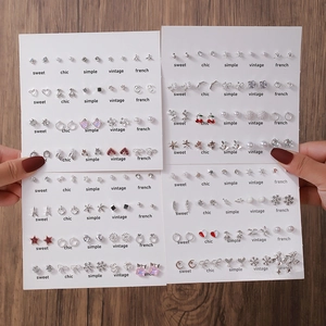 Détails d'un ensemble de boucles d'oreilles en alliage avec perles et strass sur cartes