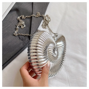 Close-up of snail-shaped silver evening bag with spiral texture and chain strap