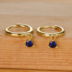S925 sterling silver hoop earrings with dark blue gemstone pendants on a wood surface