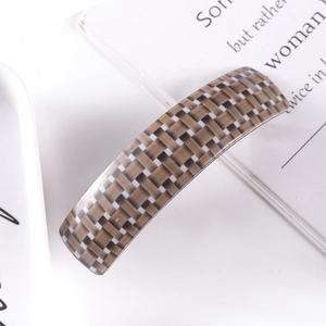 Close-up of long acetate hair clip with brown and beige woven pattern texture