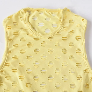 Detailed close-up of yellow sleeveless crop top showing hollow-out fabric and knit texture