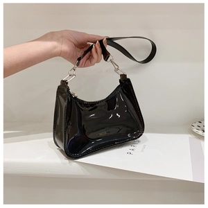 Close-up of a black glossy PVC jelly shoulder bag displayed on a white minimal podium