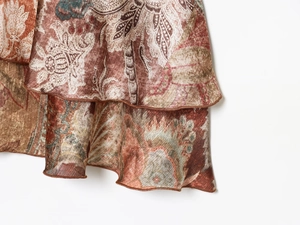 Détail d'une robe courte à imprimé bohème montrant l'ourlet à volants doublé et le motif paisley