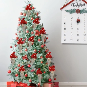 Red knit mushroom gnomes hanging on a Christmas tree with white polka dot hats