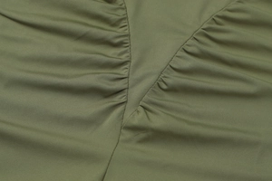 Detaillierte Nahaufnahme der olivgrünen Raffung an einem schmal geschnittenen Kleid