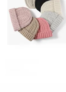 Close-up of colorful thick cable knit beanies showing detailed texture and folded cuff