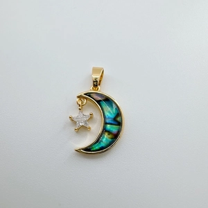 Detailed view of 18k gold plated star and moon pendant with iridescent shell and zircon