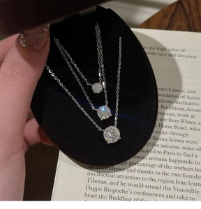 Detailed comparison of three round zircon pendant necklaces in various sizes on velvet