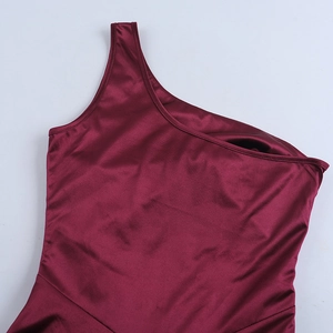 Detail showing the burgundy satin fabric texture and elegant one-shoulder dress design