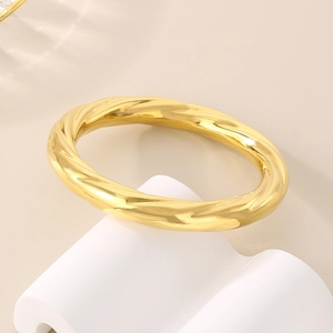Detailed view of the 18K gold plated spiral twist pattern on the stainless steel bangle