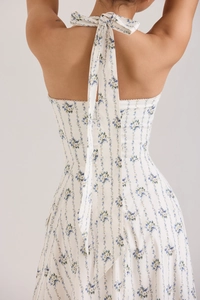 Close-up of halter neck backless floral dress featuring a blue flower pattern and bow tie