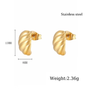 Macro detail of gold brushed stainless steel croissant earrings with spiral texture