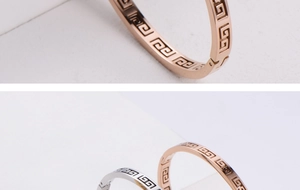 Detailed view of Greca pattern engraving on polished rose gold and silver bangles