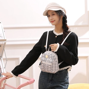 Fashionable mini backpack with snake skin pattern showing size on female model