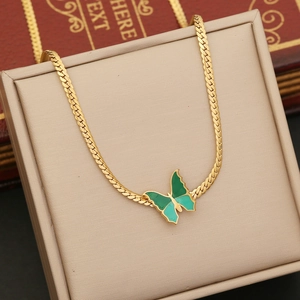 Golden flat snake chain necklace featuring a green butterfly pendant on a beige display pad