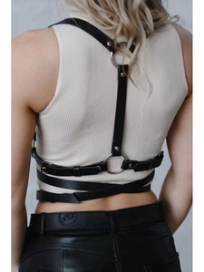 Detailed back view of a black punk PU leather harness with silver rings and crisscross straps