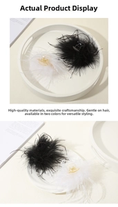 Detail view of fluffy black and white ostrich feather hair clips on a ceramic plate