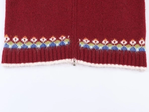 Detail of burgundy knit cardigan featuring colorful jacquard hem and metal zipper close-up