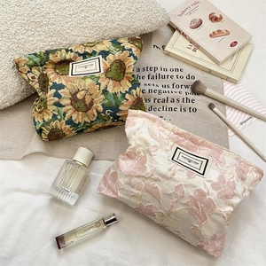 Detailed shot of jacquard floral cosmetic bags with Pleasant Time label and fabric texture