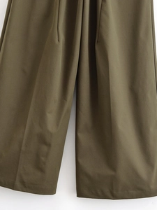 Detailed close-up of olive green high-waisted wide-leg trousers showing fabric texture