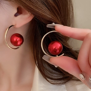 Vintage C-shaped gold earrings with red imitation pearls on model for a French chic style