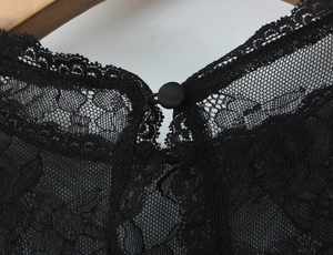 Vue détaillée du col en dentelle noire avec maille et bouton en tissu délicat