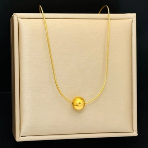 Elegant gold titanium steel ball pendant necklace with smooth snake chain on display