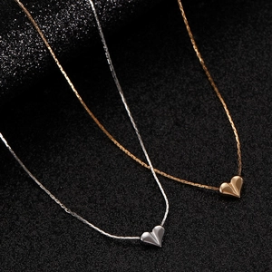 Exquisite gold and silver heart pendant necklaces with luxury snake chain on black background