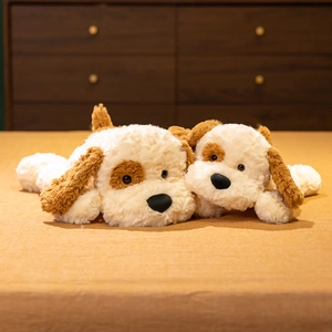 Soft cartoon plush dog pillows in two sizes with brown ears on a cozy home bed