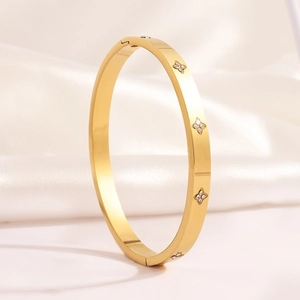 Luxurious gold clover bangle in titanium steel with sparkling cubic zirconia inlay