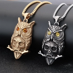 Macro view of vintage owl skull pendants with set zircons in gold and silver finishes