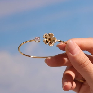 Gold-plated open bangle with sparkling round zircon and micro-set five-petal flower detail