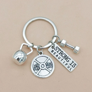 Silver dumbbell kettlebell keyring with Strong Is Beautiful tag for fitness lovers