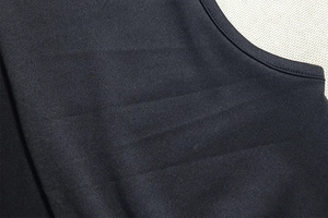 Close-up of the ribbed texture and stitching detail on the black knit fabric dress