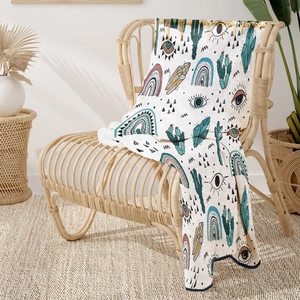 Detailed view of bohemian flannel blanket with ethnic patterns on a rattan chair