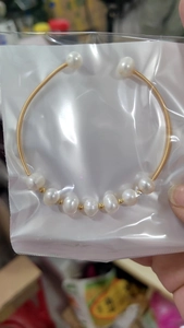 Detail of a handmade gold wire wrapped pearl bracelet with elegant vintage open design