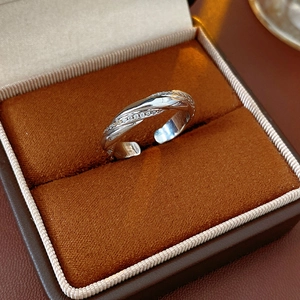 Macro shot of silver twisted ring with zircon inlay placed in a luxury brown suede jewelry box